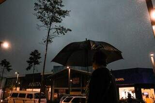 Morador da Capital circula sob guarda-chuva na Rua 14 de Julho, no Centro. (Foto: Henrique Kawaminami/Arquivo)