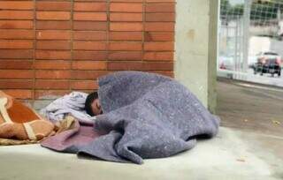 Morador de rua dormindo na calçada, na região central de Campo Grande (Foto: Kisie Ainoã)