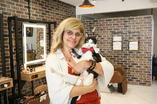 Maiara Corral e Arnold, o gato que inspirou o nome da barbearia. (Foto: Henrique Kawaminami)