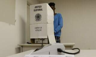 Eleitor na cabine de votação exercendo o direito de escolher democraticamente seus representantes na política. (Foto: Fernando Frazão/Agência Brasil)