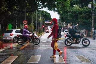 Mulher com guarda-chuva e casaco na rua do centro da cidade, em Campo Grande (Foto: Henrique Kawaminami)