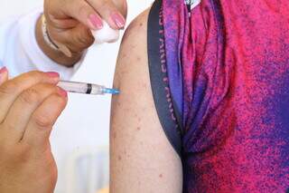 Rapaz recebe dose de vacina contra covid-19 em Campo Grande. (Foto: Kísie Ainoã)