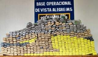 Pilha de tabletes de maconha encontrados no veículo. (Foto: PMR)