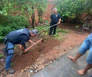 Policiais fazem busca no quintal da casa de um dos suspeitos. (Foto/Divulgação)