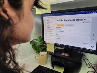 Eleitora acessa site do TSE (Tribunal Superior Eleitoral) em computador. (Foto: Caroline Maldonado)