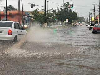 Carro passando em avenida que virou rio em Campo Grande. (Foto: Direto das Ruas)