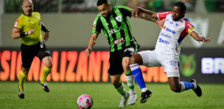 Disputa de bola durante a partida desta noite. (Foto: Mourão Panda / América-MG) 