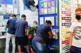 Clientes sendo atendidos em lotérica da Capital. (Foto: Henrique Kawaminami)