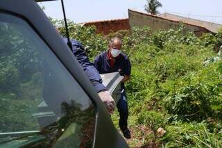 Corpo é retirado de terreno baldio, no Jardim Leblon. (Foto: Henrique Kawaminami)