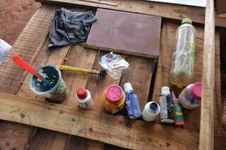 Tintas acabando, pincel gasto e garrafinha com água integram os materiais de Rone. (Foto: Paulo Francis)