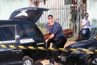 Agentes funerários levam corpo de homem executado na tarde deste sábado. (Foto: Marcos Maluf)