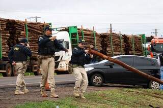 Policiais auxiliam na retirada de madeira usada no protesto. (Foto: Henrique Kawaminami)