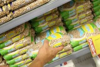 Consumidora segura pacote de feijão em supermercado na Capital; entidades afirmam que há estoque suficiente. (Foto: Kísie Ainoã)
