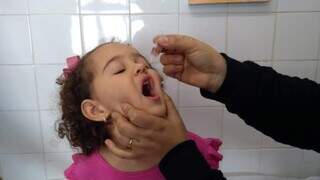 Criança tomando vacina em gotas contra a poliomielite (Foto: Divulgação/Prefeitura de Campo Grande)