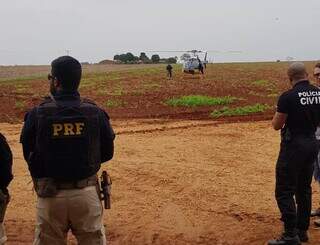Policiais que participam da operação conjunta e ao fundo o helicóptero da PRF (Foto: Divulgação)