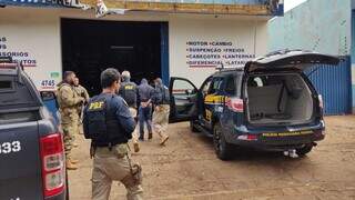 Policiais chegam à loja de peças em Dourados com um dos presos na operação de hoje (Foto: Adilson Domingos)