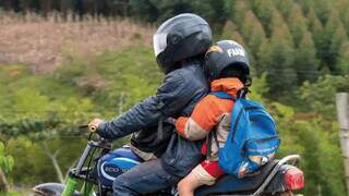 Adulto e criança sobre motocicleta (Foto: Detran-MS)