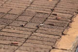 Cápsulas deflagradas de fuzil ficaram caídas na calçada de loja (Foto: Marcos Maluf)
