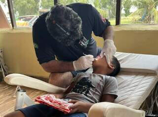 Dentista realiza atendimento de criança pantaneira. (Foto: Divulgação)