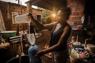 Francisca fabricando sabão líquido com óleo usado doado por vizinhos (Foto: Marcos Maluf)