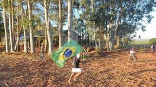 Indígena corre segurando bandeira do Brasil em Amambai, palco do &#34;Massacre de Guapoy&#34;, em junho deste ano. (Foto: Helio de Freitas/Arquivo)