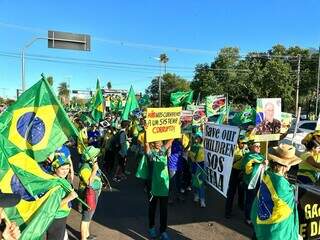 Mulheres vestidas de verde e amarelo, com bandeiras e palavras de ordem em faxias. (Foto: Kisie Ainoã)