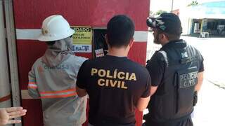 Funcionário da Energisa e policiais civis no local onde o furto foi comprovado. (Foto: Direto das Ruas)