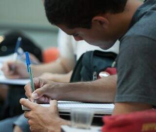 Estudante escrevendo em seu caderno dentro de uma sala de aula. (Foto: Ascom/MEC)