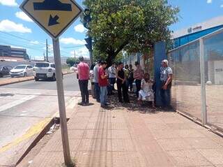 Candidatos que chegaram cedo na Uniderp se espremiam por uma sombra antes da abertura dos portões. (Foto: Gabriela Couto)