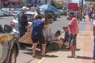 Banner e sombrinha foram usados para proteger a idosa do sol. (Foto: Marcos Maluf)