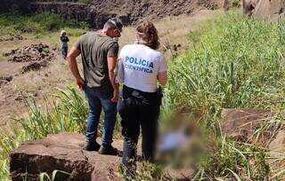 Perita da Polícia Civil ao lado do corpo de Alonso Cabreira, na Aldeia Bororó (Foto: Adilson Domingos)