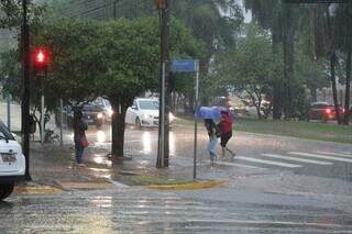 Pessoas fugindo da chuva no Centro de Campo Grande (Foto: Kísie Ainoã)
