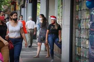 Funcionária em frente a loja, em época de Natal (Foto: Henrique Kawaminami)