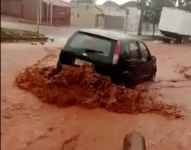 Carro levado pela enxurrada &eacute; salvo por pilastra de concreto no Nova Lima