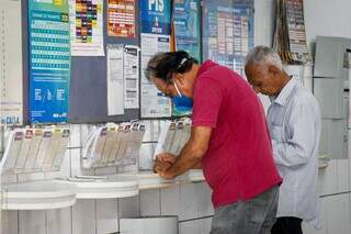 Apostador anotando os números da sorte no canhoto da loteria (Foto: Henrique Kawaminami/Arquivo)