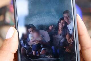 Mãe mostra foto no celular, dos gêmeos ao lado do irmão caçula. (Foto: Arquivo)