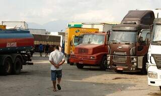 Motorista andando em meio a vários caminhões e carretas estacionados. (Foto: Tomaz Silva/Agência Brasil)