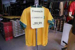 Camiseta da Seleção em promoção no Centro de Campo Grande nesta terça (13) (Foto: Kisie Ainoã)