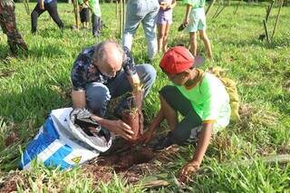 Gabriel ajuda a plantar guavira em área perto da pista de caminhada, que ganhou 50 mudas. (Foto: Paulo Francis)
