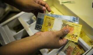 Pessoa manuseia cédulas de dinheiro. (Foto: Agência Brasil)
