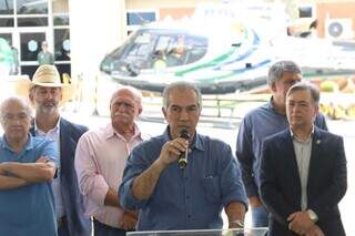 Reinaldo Azambuja discursa ao microfone durante entrega de helicóptero (ao fundo). (Foto: Paulo Francis)