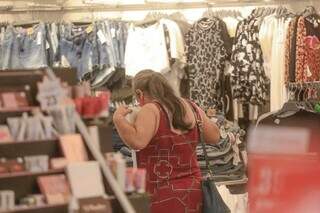 Mulher mede peça de roupa me loja de Campo Grande. (Foto: Marcos Maluf)