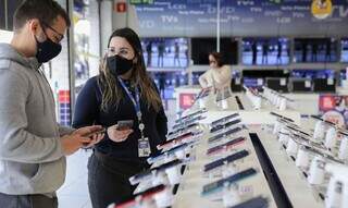 Vendedora atende cliente em loja de celulares. (Foto: Agência Brasil)