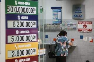 Senhora escolhe números para fazer aposta em lotéria da Capital (Foto: Marcos Maluf)