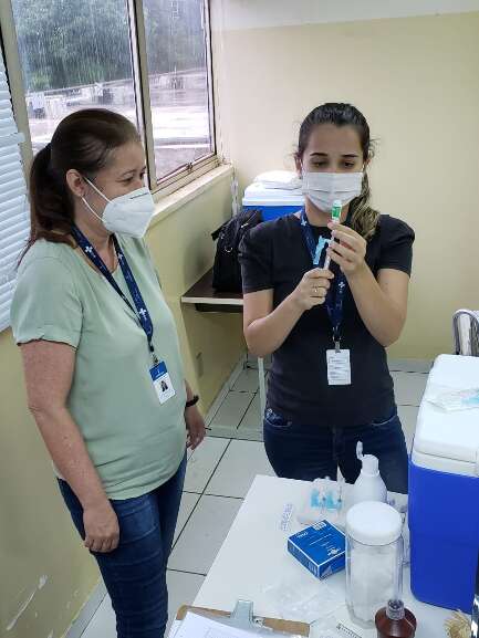 Marcele prepara dose da vacina para aplicar em colega de trabalho. (Foto: Arquivo Pessoal)
