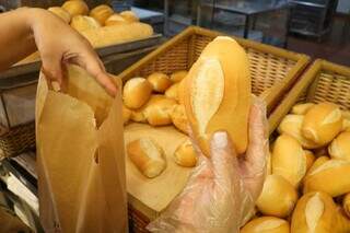Cliente pega pão francês em padaria da Capital (Foto: Henrique Kawaminami)