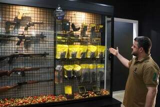 Paulo Zarabatana mostra armamentos disponíveis na loja (Foto: Henrique Kawaminami)