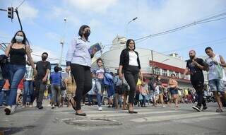 Pessoas andam de máscara pelas ruas. (Foto: Agência Brasil)