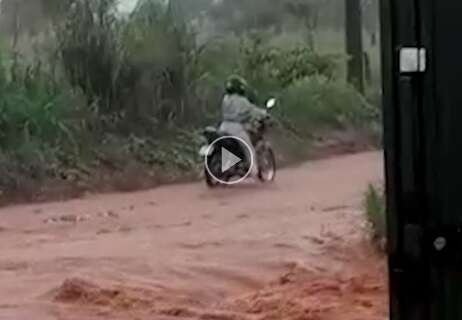 Embaixo de chuva forte, motociclista tenta desatolar moto no Jardim Noroeste