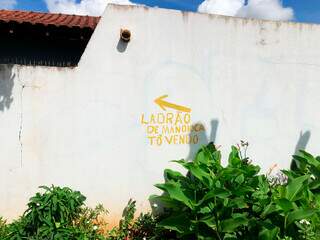 Aviso foi escrito em tinta amarela no muro da casa de Hélio. (Foto: Jéssica Fernandes)